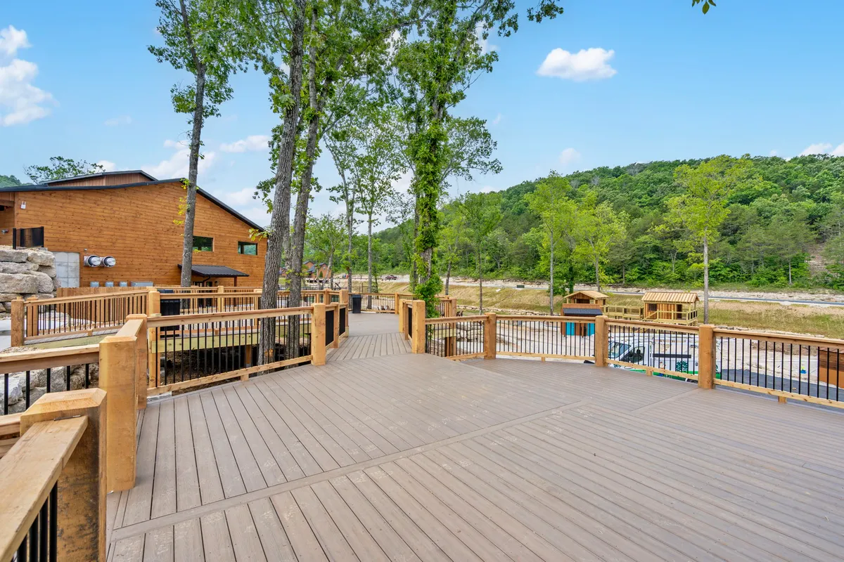 A tranquil wooden deck surrounded by trees, with views of distant hills—an inviting outdoor extension of the kitchen and dining areas. This deck setting is perfect for enjoying morning coffee or after-dinner relaxation in the fresh Ozark air.